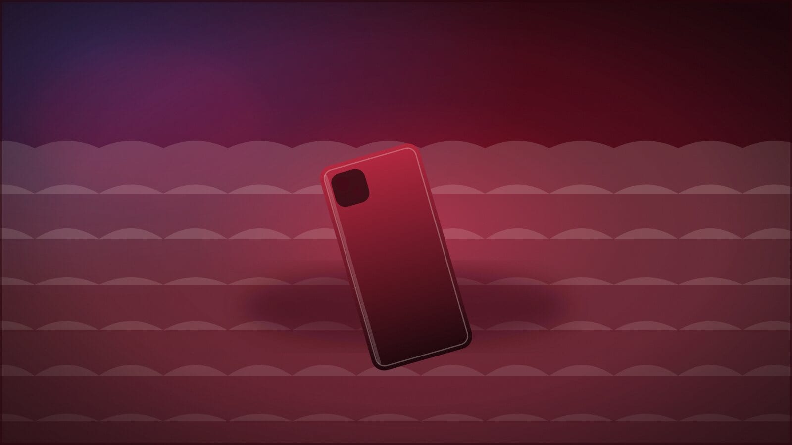 A phone lying face-down on a rumpled bed in warm low light.